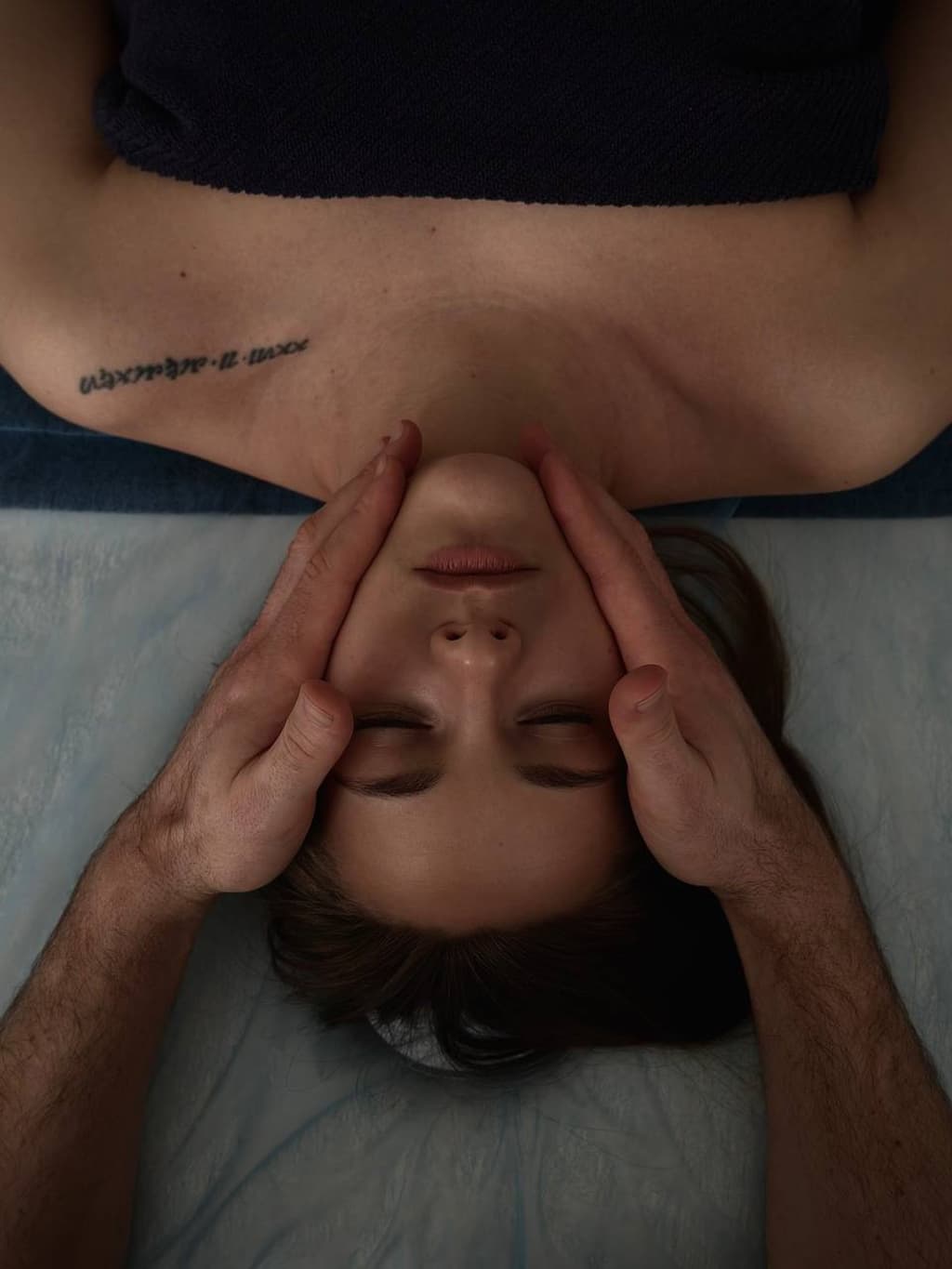 Руки масажиста на обличчі клієнтки